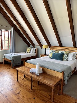 superior triple room with en-suite bathroom, sitting area and views overlooking the Drakensberg Mountains