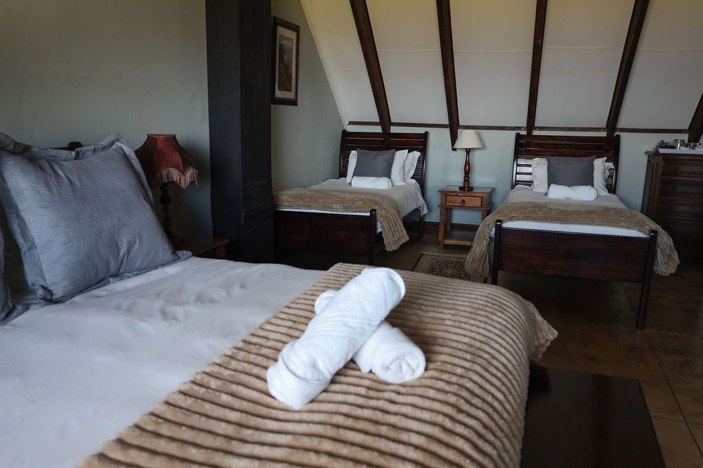 Room 3 Upstairs Family sleeps a family of four in a comfortable queen bed and two single bed, complete with en-suite bathroom and views overlooking the Drakensberg Mountains 