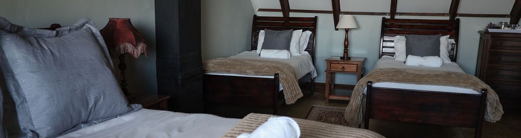 Room 3 Upstairs Family sleeps a family of four in a comfortable queen bed and two single bed, complete with en-suite bathroom and views overlooking the Drakensberg Mountains 