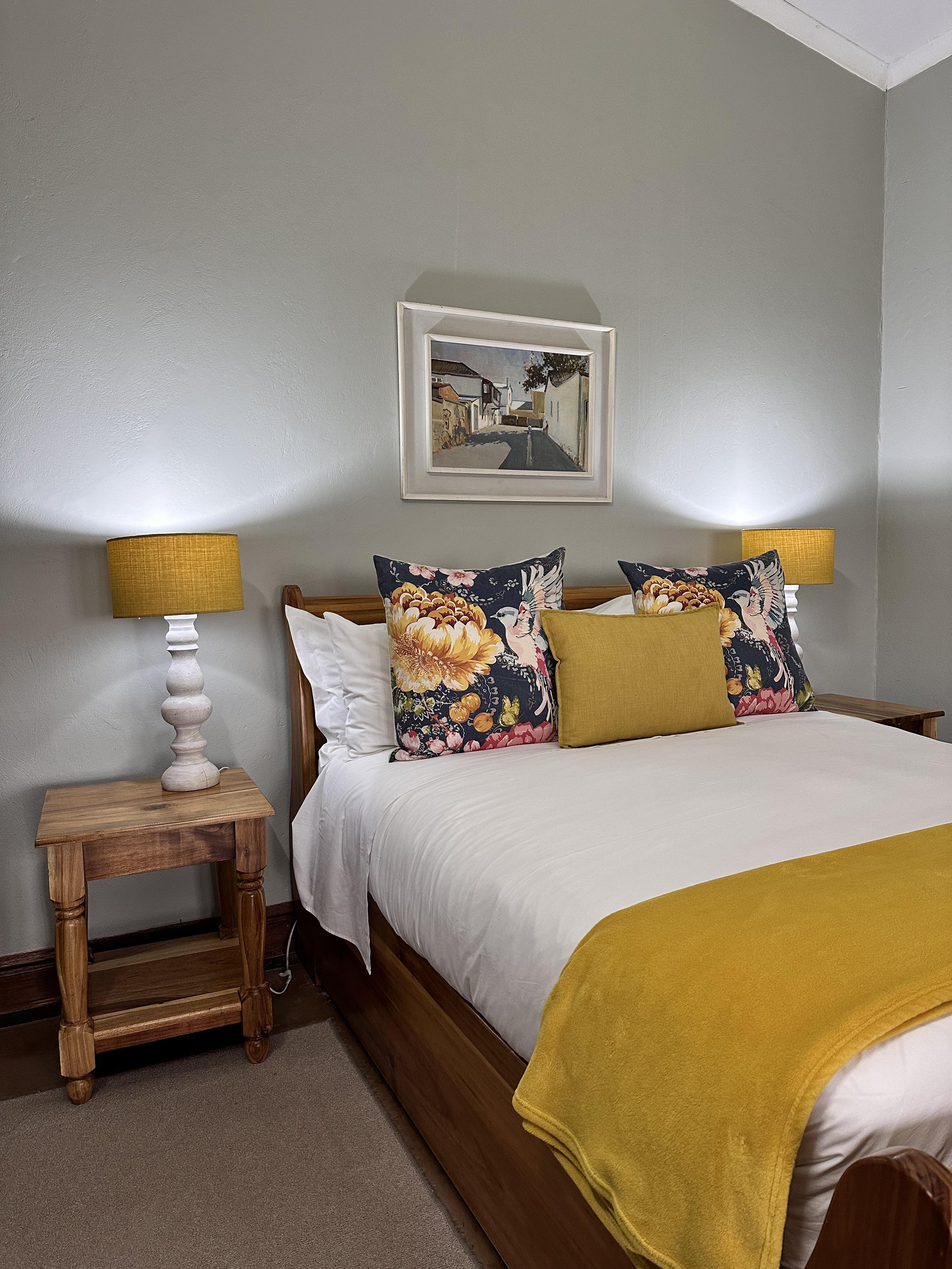 Room 5 Superior Downstairs Queen with a fireplace, seating area, en-suite bathroom with bathtub and enclosed porch overlooking the magnificent Drakensberg Mountains