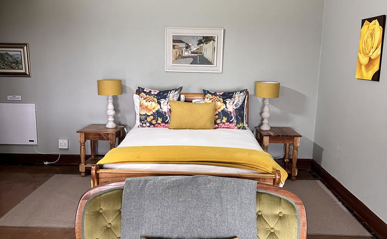 room 5 superior downstairs queen with seating area, fireplace, en-suite bathroom and double shower and closed-in porch overlooking Drakensberg Mountains