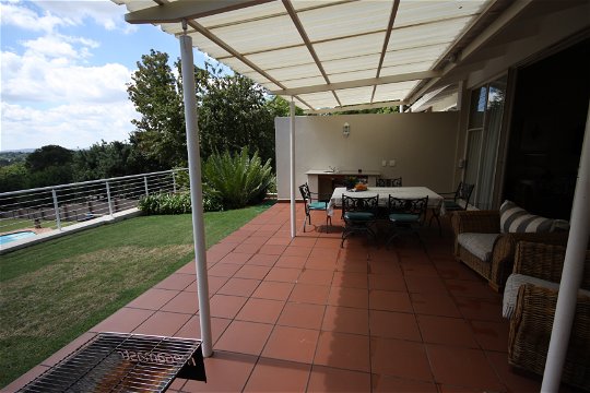 Apartment 1: Patio with view over garden & braai facilities