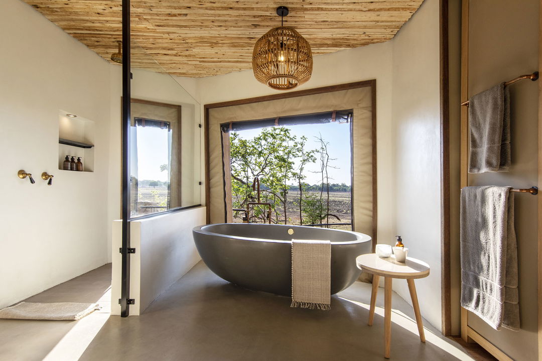 bathroom with views of plains beyond at Puku Ridge Camp Zambia