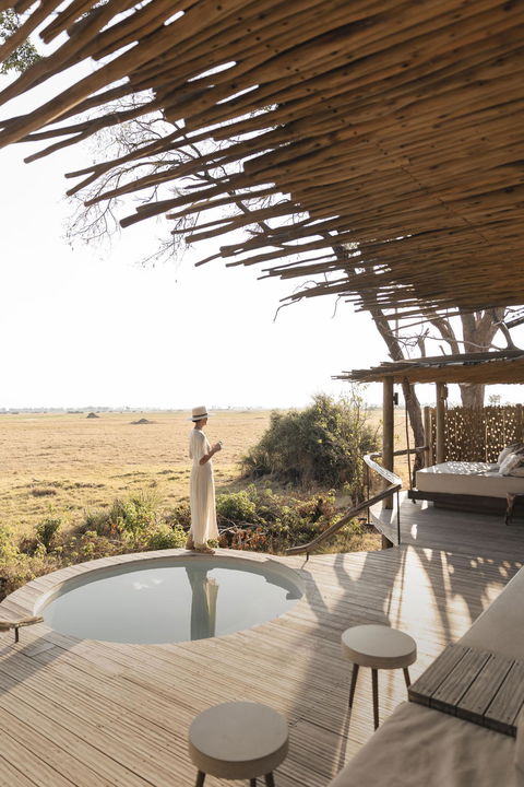 lady on patio deck by splash pool at Mombo camp Botswana