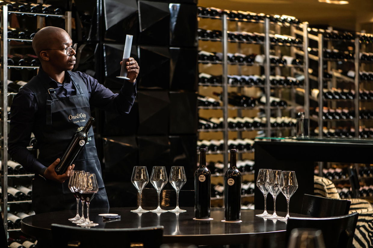 sommelier in wine cellar tasting wine at one&only hotel cape town