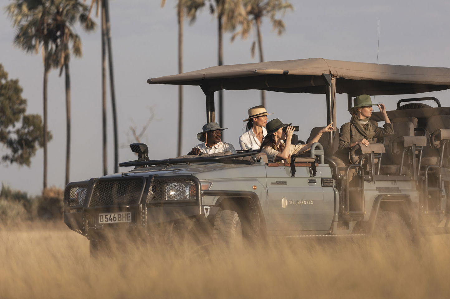 safari vehicle with guests on a game drive at Wilderness Mombo Camp in the Okavango Delta