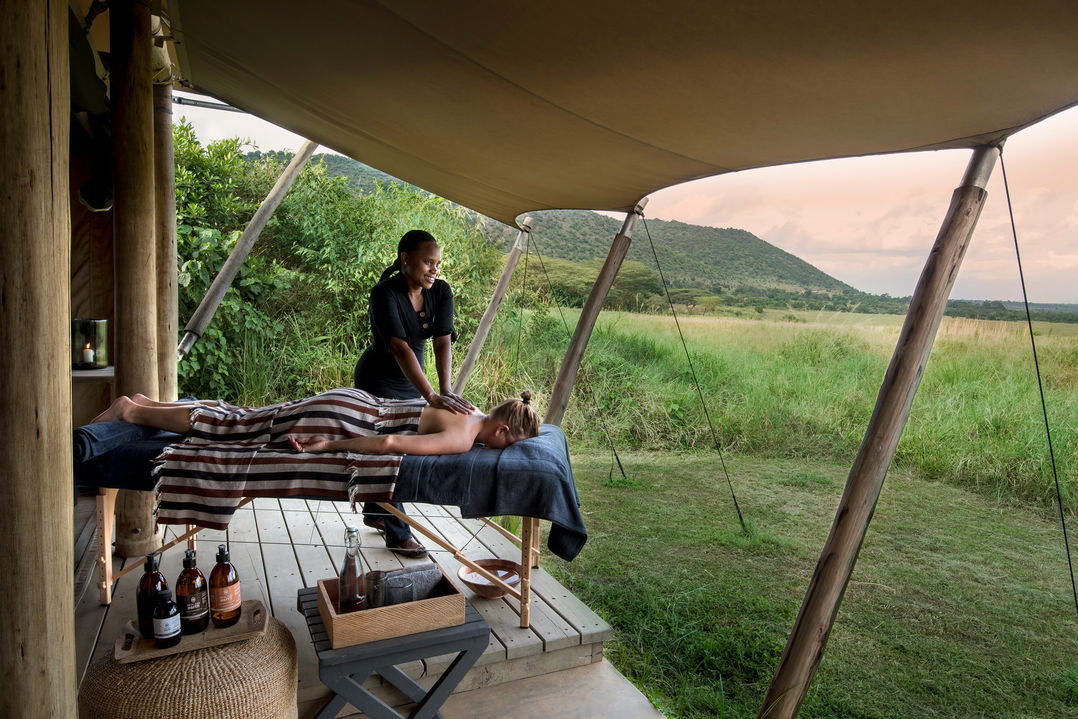 guest getting a message outside suite of andBeyond Kichwa Tembo Camp Kenya Masai Mara