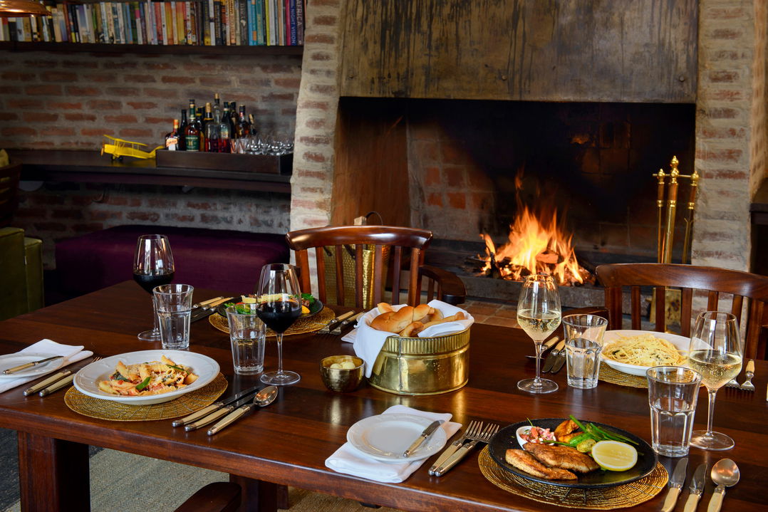 dinner setting by fireplace in dining area of Angama Mara Kenya Masai Mara