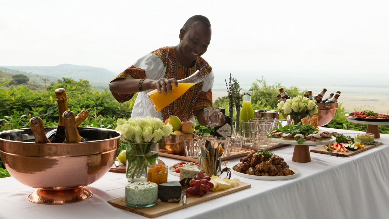 food and drinks spread on a table on deck by Angama Mara Kenya Masai Mara