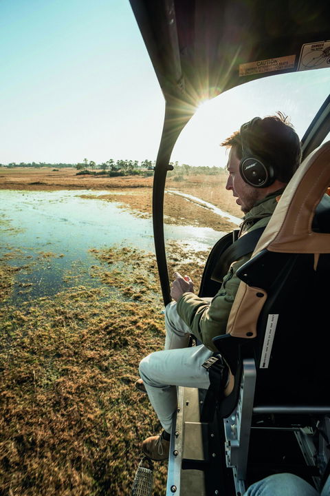 male guest in a helicopter over the Okavango delta at Belmond Eagle Island Lodge