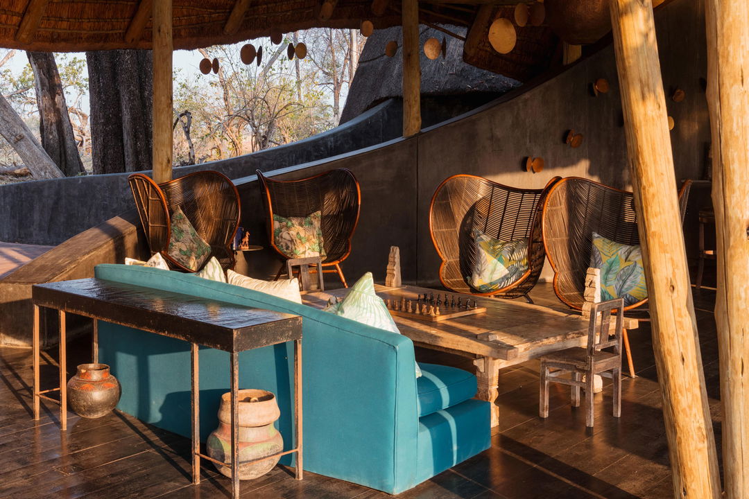 sunlit view of lounge with table and chess board on main deck of Belmond Eagle Island Lodge