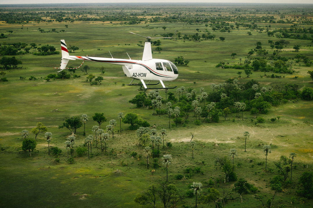 white helicopter soaring above the Okavango delta at Belmond Eagle Island Lodge