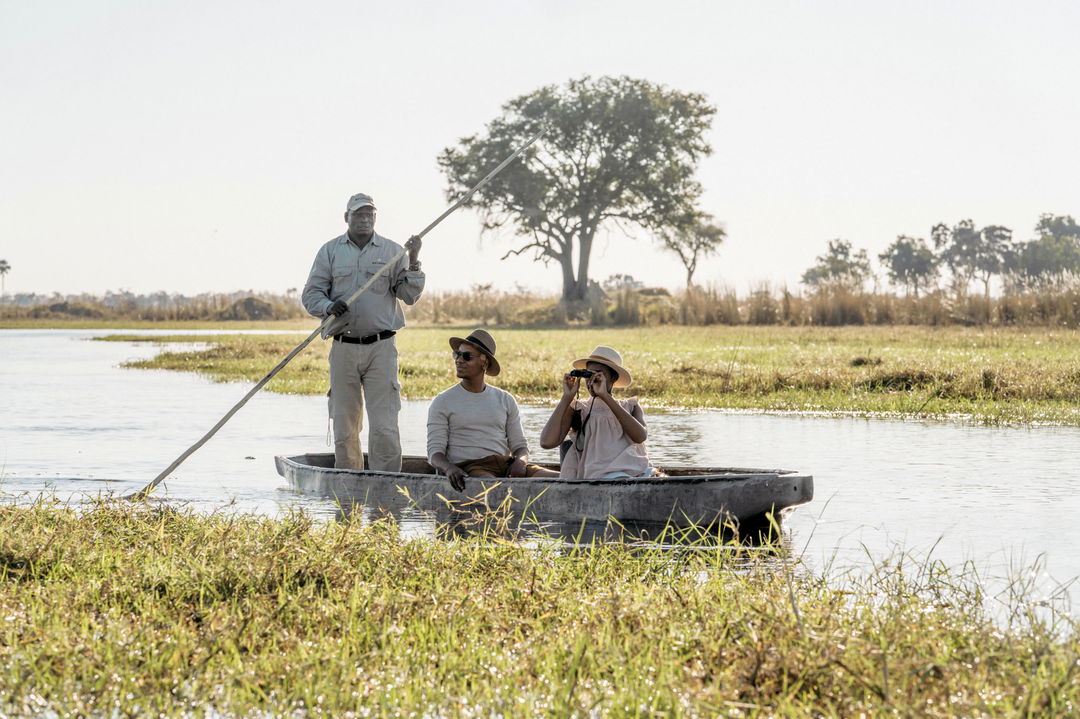 guide with guests in mokoro sighting wildlife on delta at Belmond Eagle Island Lodge