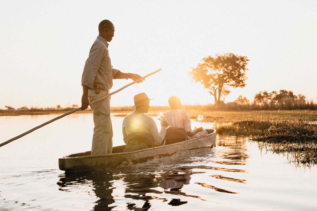 guide with two guests on a sunset mokoro ride on delta by Belmond Eagle Island Lodge