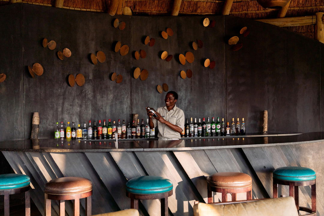 barman mixing drinks behind the bar of Belmond Eagle Island Lodge