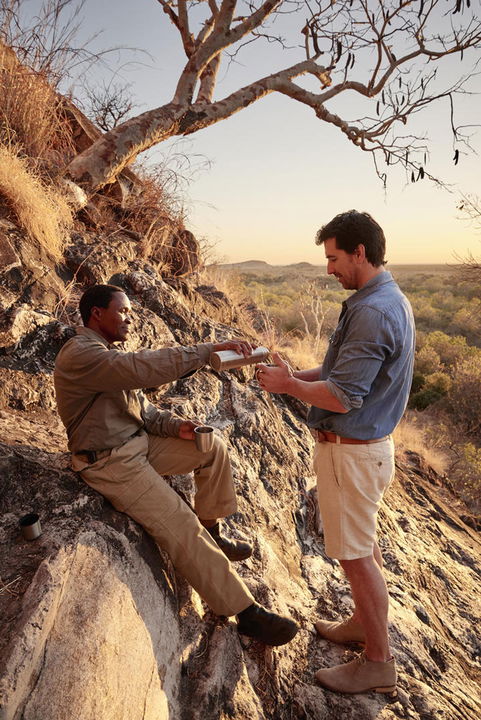 guest and guide under a tree looking at map at Savute elephant lodge Belmond