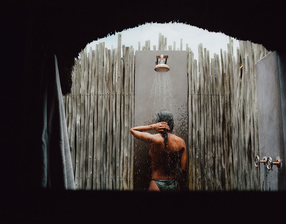 guest taking an outside bush shower at Belmond Savute elephant lodge