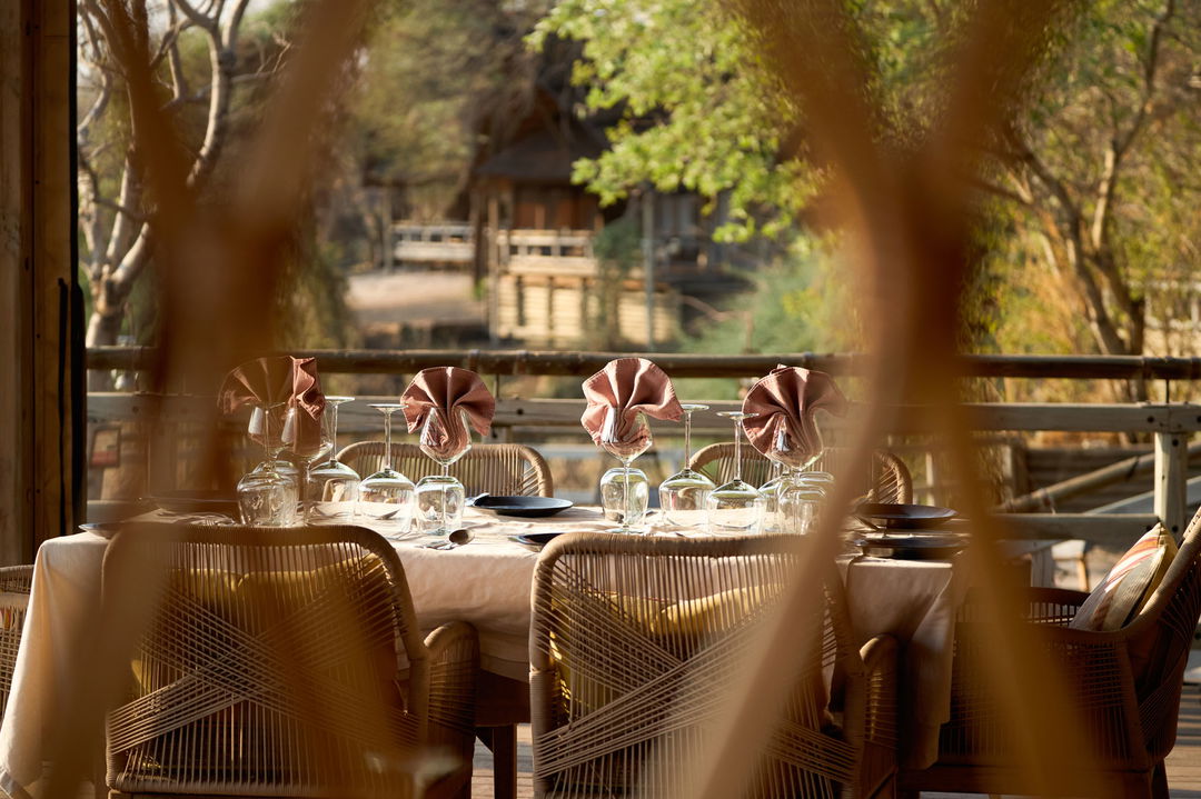 dining area on deck with decorated tables at Savute elephant lodge Belmond