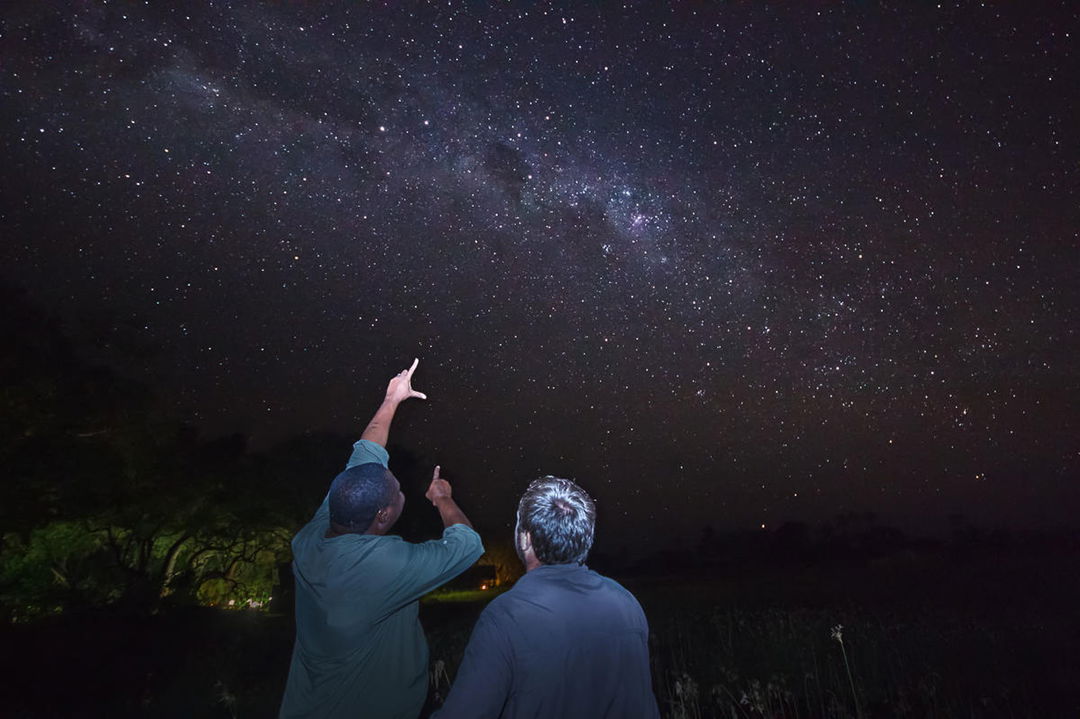 two guests looking at star formations at night at Savute elephant lodge Belmond