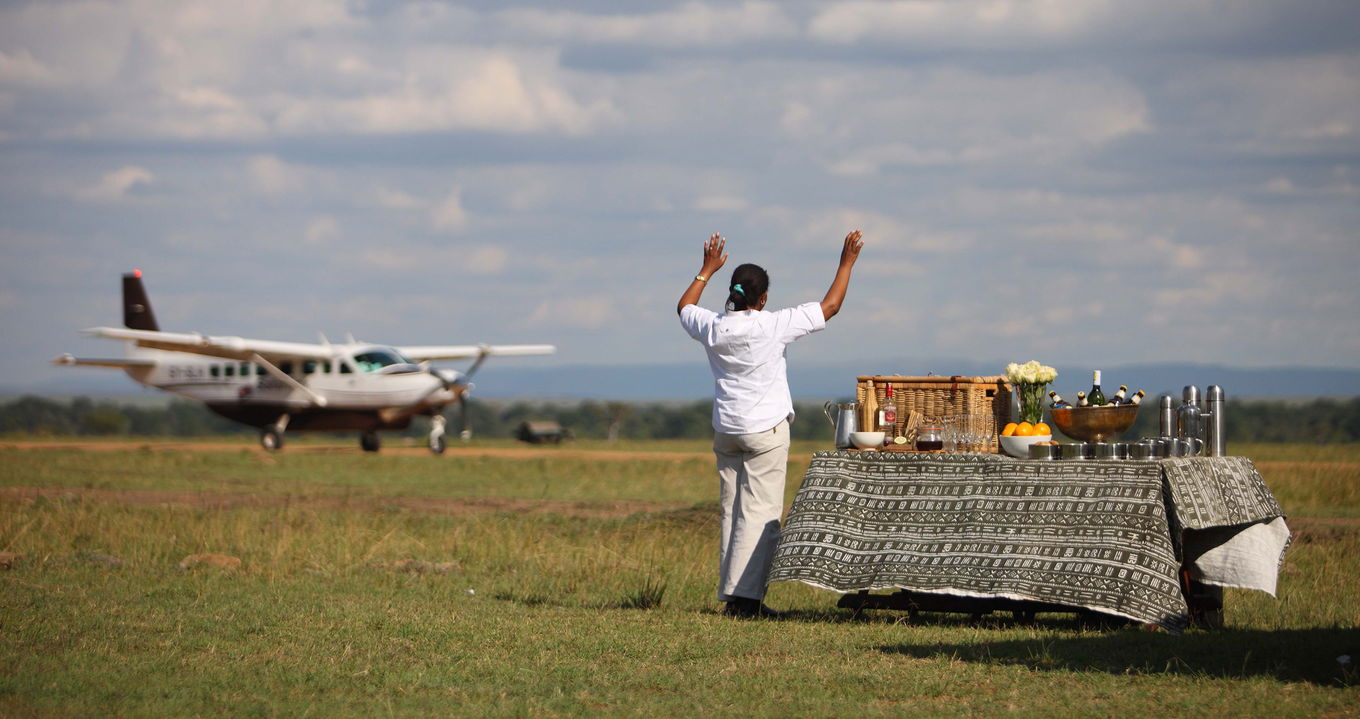 staff on airstrip welcoming guests to andbeyond Bateleur camp Kenya Masai Mara