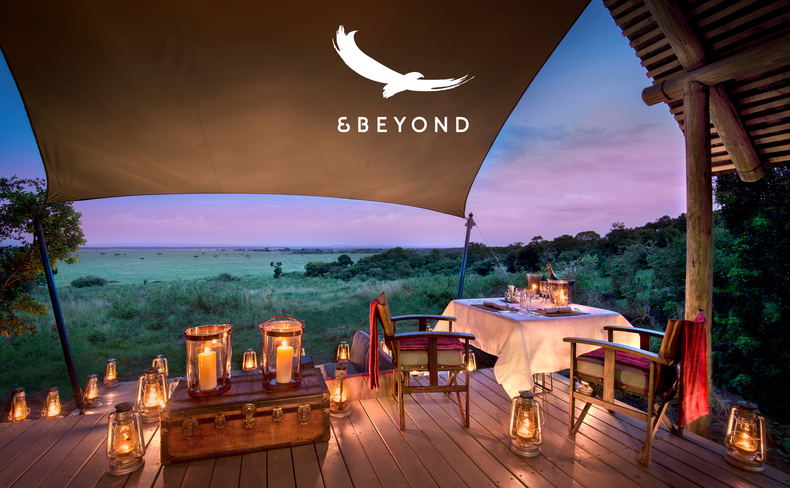 dinner setting on deck of suite at night by andbeyond Bateleur camp Kenia Mara with logo overlay dinner setting on deck of suite at night by andbeyond Bateleur camp Kenia Mara with logo overlay