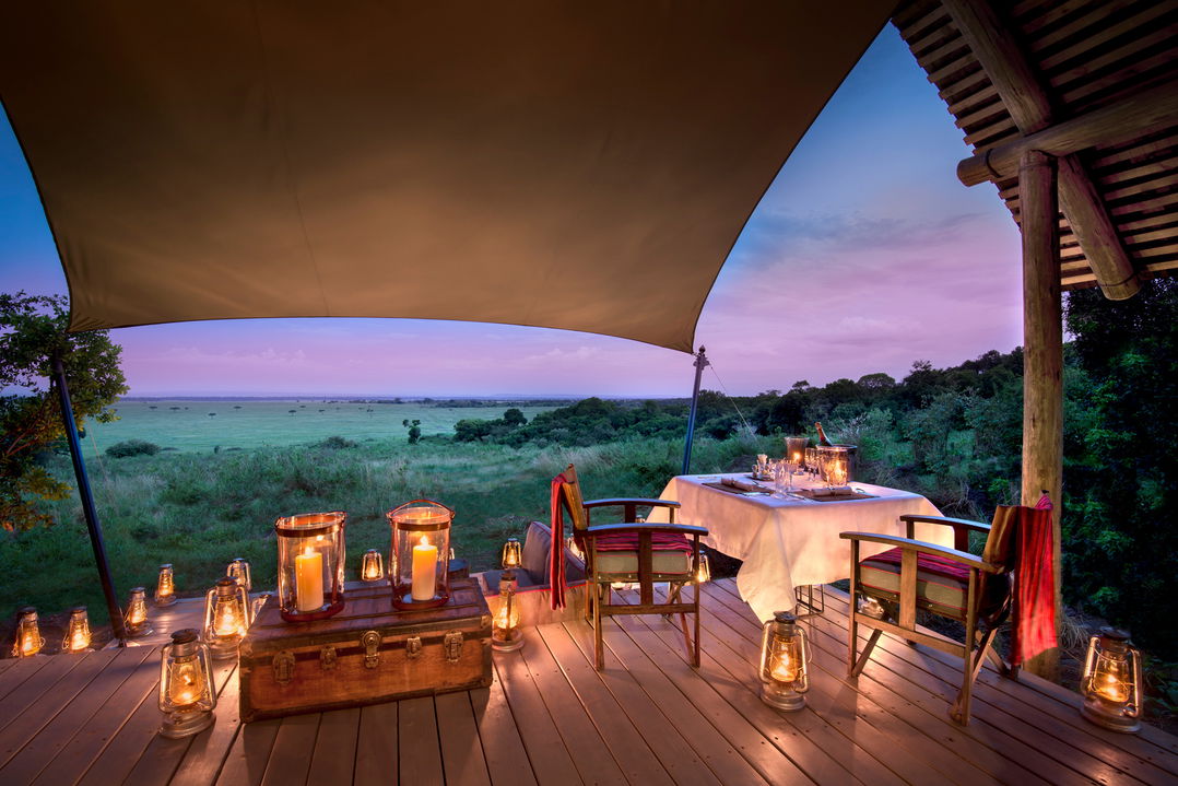 dinner setting on deck of suite at night by andbeyond Bateleur camp Kenia Mara