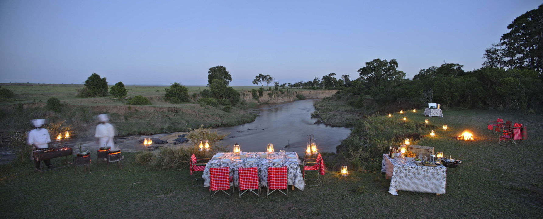 dinner setting by the river at night by andbeyond Bateleur camp Kenya Masai Mara