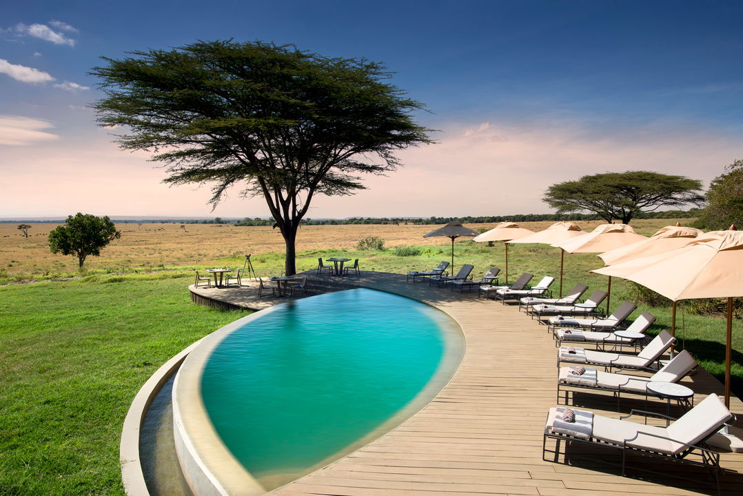 swimming pool with loungers on deck and views at andbeyond Bateleur camp Kenya Masai Mara