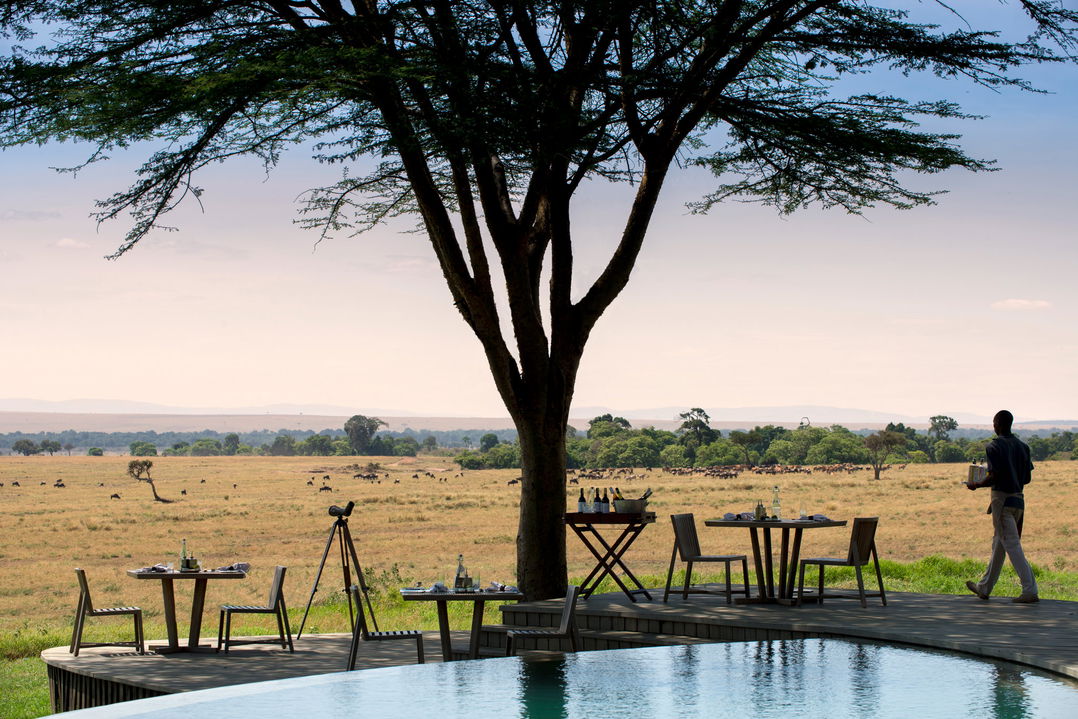 dining table under tree by pool of andbeyond Bateleur camp Kenya Masai Mara