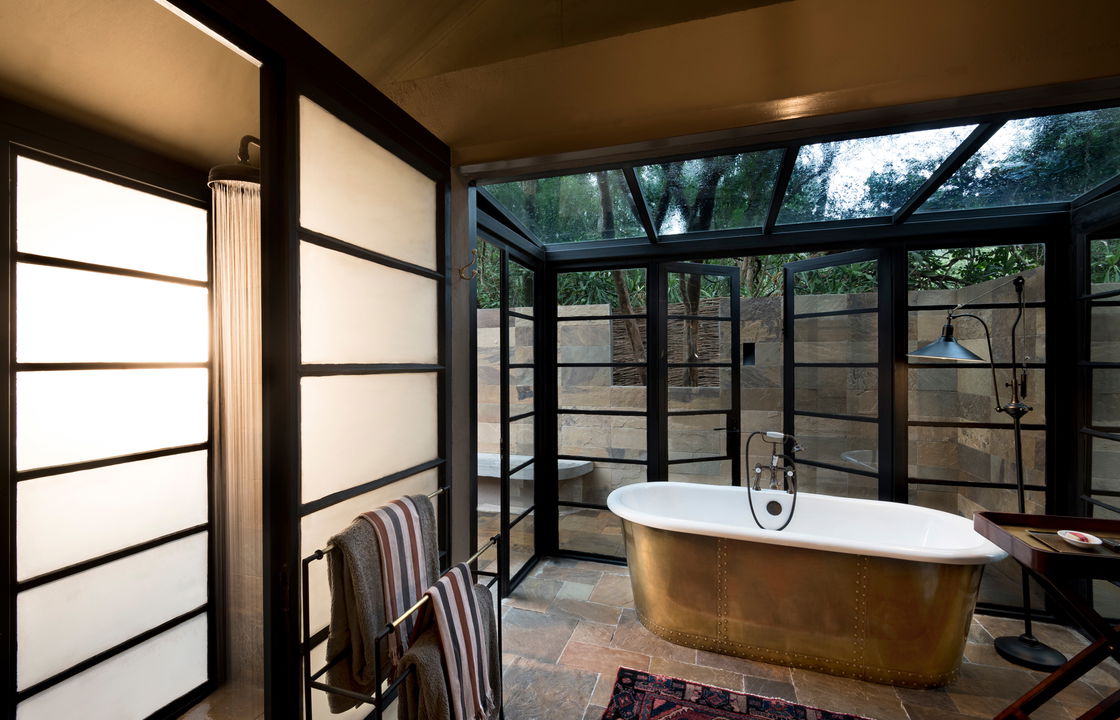 bathroom view with big windows and copper tub at andbeyond Bateleur camp Kenya Masai Mara
