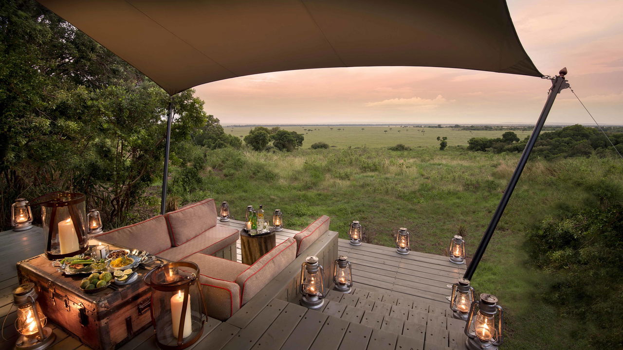 suite outside deck with lanterns at sunset by andbeyond Bateleur camp Kenya Masai Mara