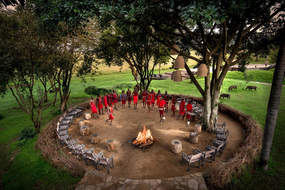 Masai warriors in the fireplace boma ready for guest dinner at andBeyond Kichwa Tembo Camp Kenya Masai Mara