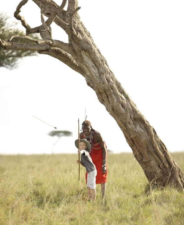 kid learning archery from Masai at andBeyond Kichwa Tembo Camp Kenya Masai Mara