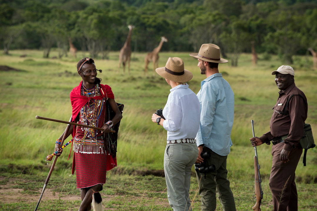 couple with Masai tracker on a walking safari at andBeyond Kichwa Tembo Camp Kenya Masai Mara