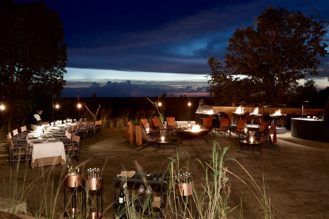evening view of fireplace boma at Chichele Presidential Camp Zambia getting ready for guest supper