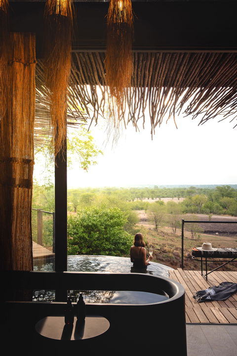 lady guest in pool on deck of Chichele Presidential Camp Zambia