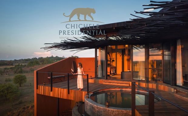 lady on deck of vista suite looking out over plains at sunset by Chichele Presidential Lodge Zambia with logo overlay lady on deck of vista suite looking out over plains at sunset by Chichele Presidential Lodge Zambia with logo overlay
