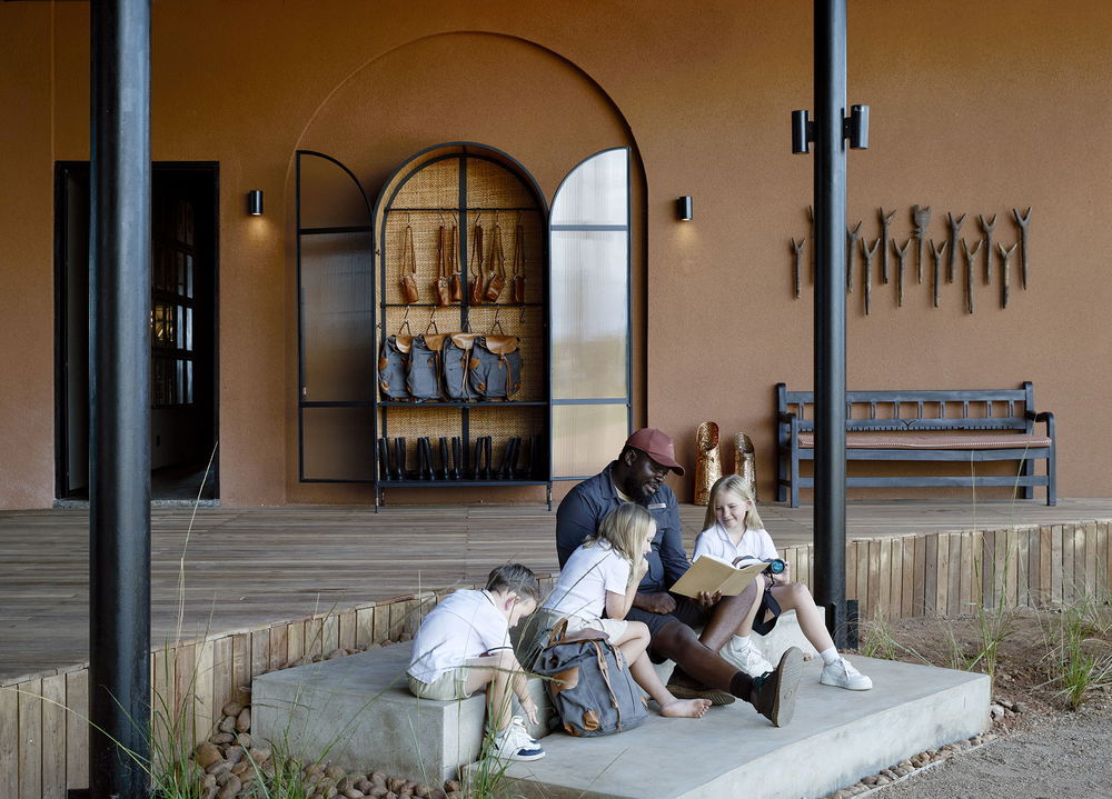 young rangers learning session on stairs of main lodge by Chichele Presidential Camp Zambia