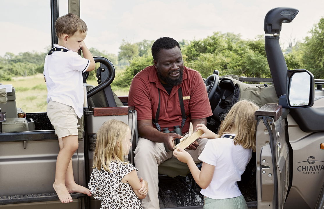 staff educating young rangers by safari vehicle at Chichele Presidential Camp Zambia