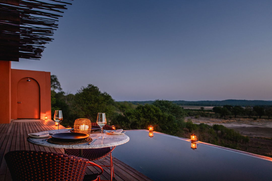 evening view of pool and plains from lodge deck at Chichele Presidential Camp Zambia