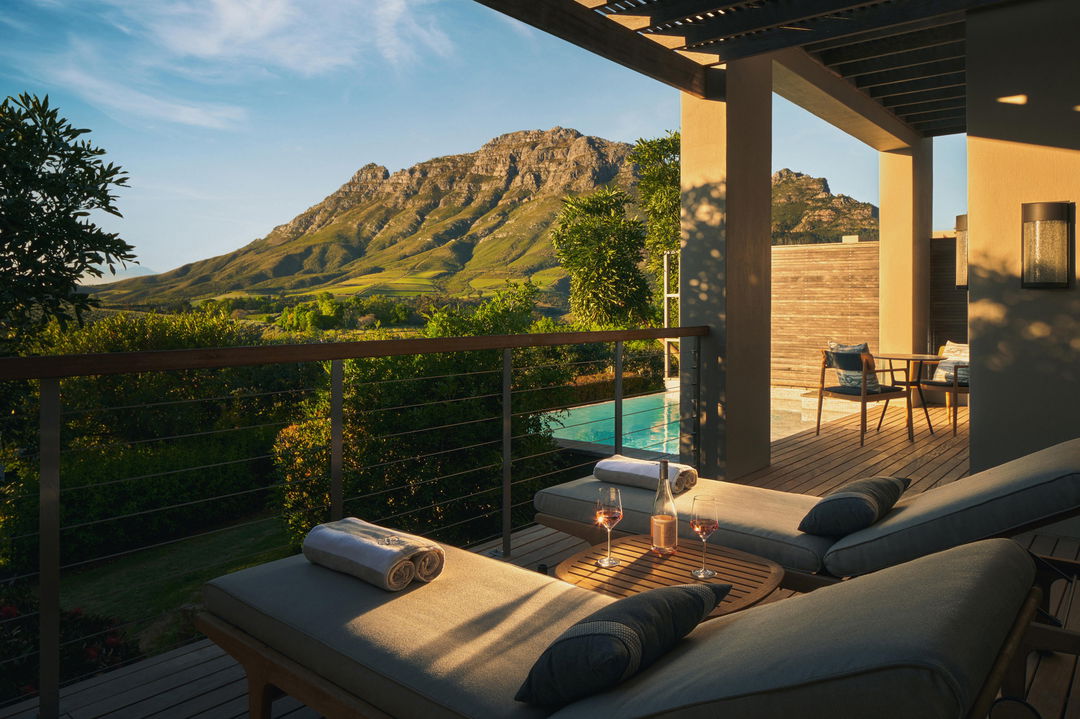 patio from private villa with pool and loungers and mountain backdrop at Delaire Graff luxury Wine estate in Franshoek