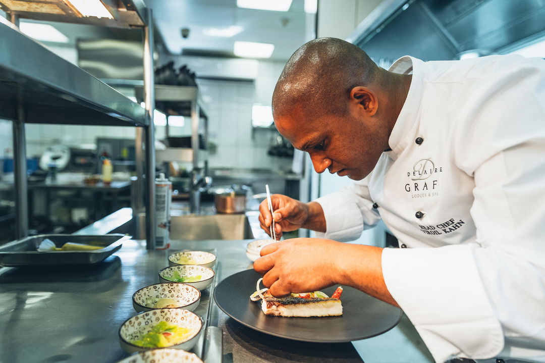 Chef preparing gourmet dishes in kitchen of Delaire Graff luxury Wine estate in Franshoek