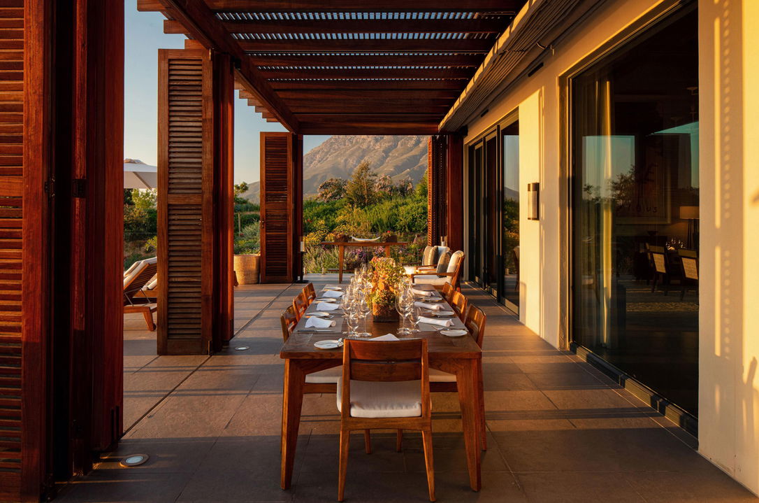 dinner table on patio of Owners villa at Delaire Graff with big open patio and views of winelands