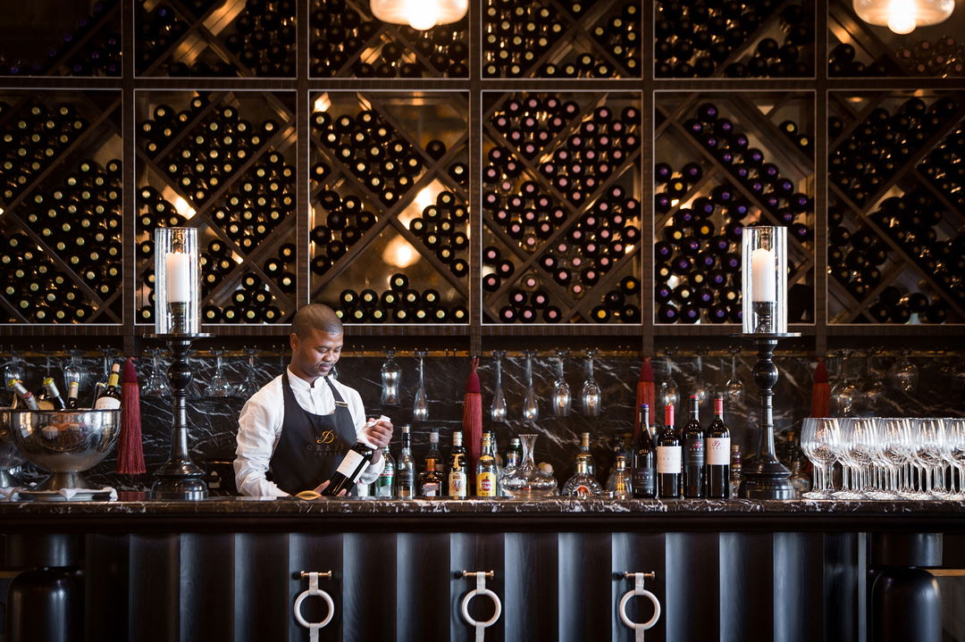 sommelier behind wine bar counter at Delaire Graff luxury Wine estate in Franshoek