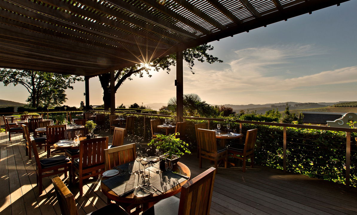 sunset view of the main deck with views and tables decorated at Delaire Graff luxury Wine Estate Franschhoek