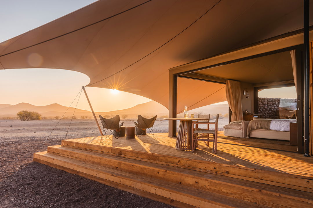 sunrise view of deck by luxury tented suite at desert rhino camp wilderness Namibia 