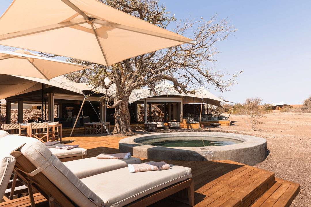 loungers by plunge pool on deck of desert rhino camp wilderness Namibia 