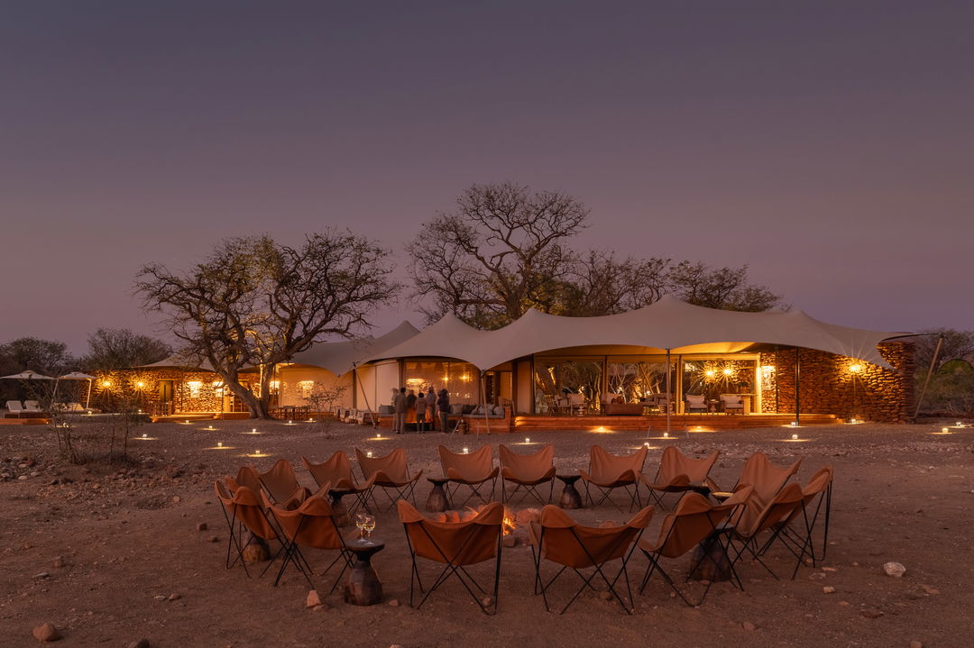 chairs in fire pit at night  at desert rhino camp wilderness Namibia 