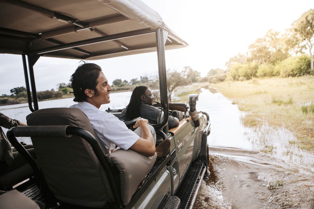 guest with safari guide in open vehicle looking to the side at Vumbura Plains Camp Wilderness Okavango Delta