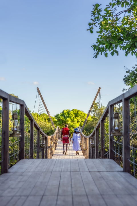 workers crossing the bridge of the JW Marriot Masai Mara Kenya